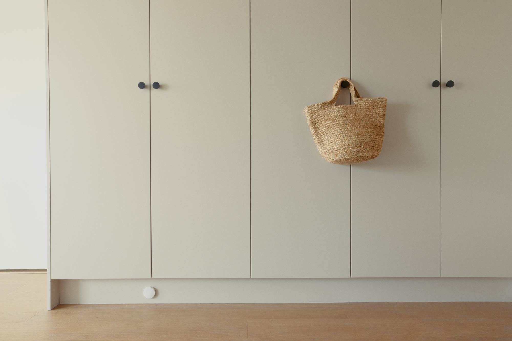A pale wall of cabinets and an oak floor in a finished home