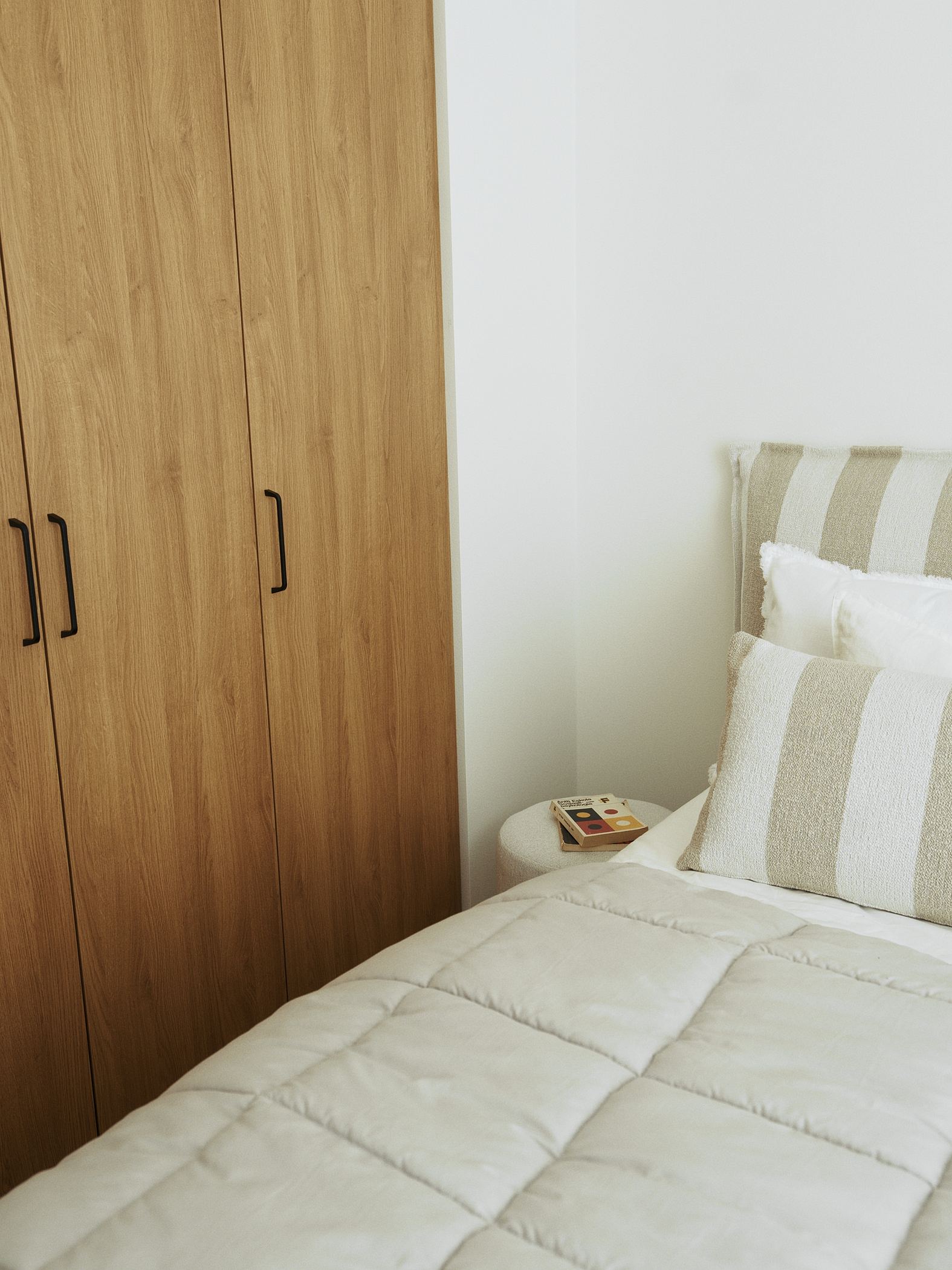 A bedroom, an oak wardrobe and striped pillows