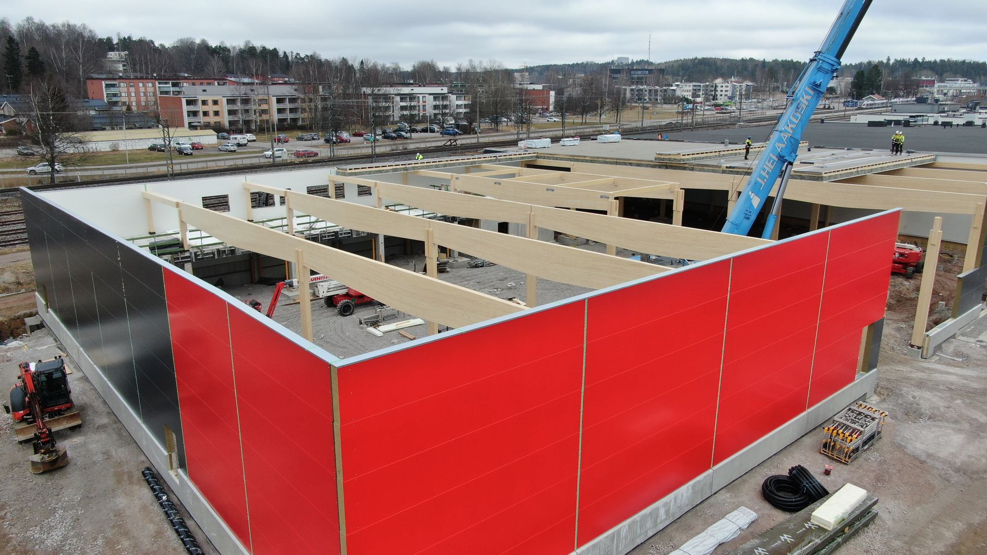The red extension of Kirkkonummen Tähti from the air, its glulam frame and a crane