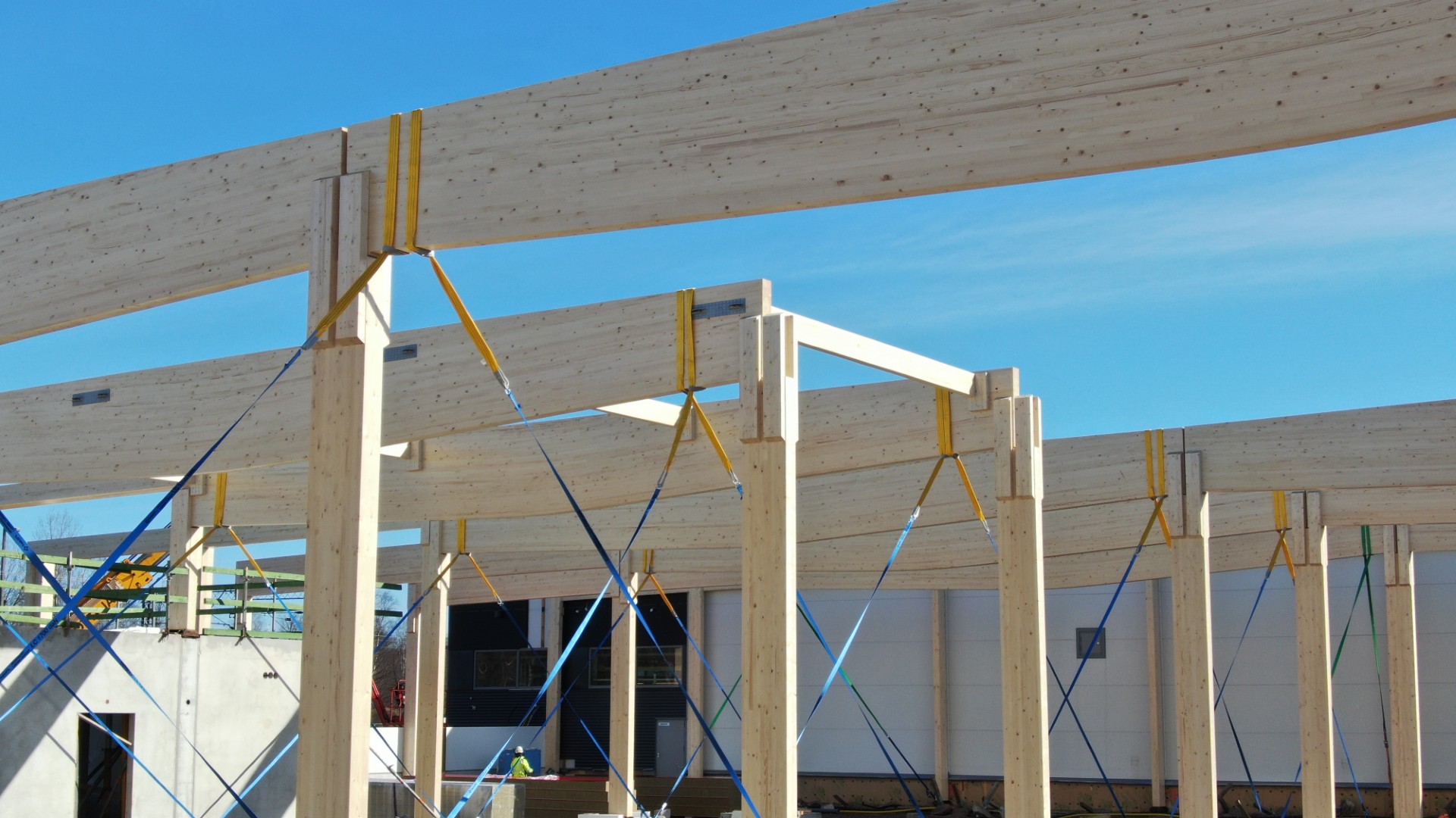 A glulam frame rising against a blue sky in Kirkkonummi